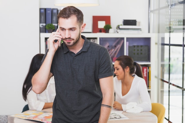 Man conversating with phone in office