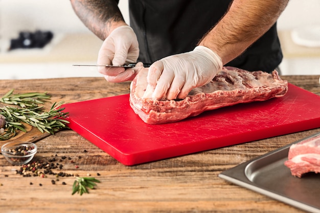 キッチンで肉ステーキを調理する男