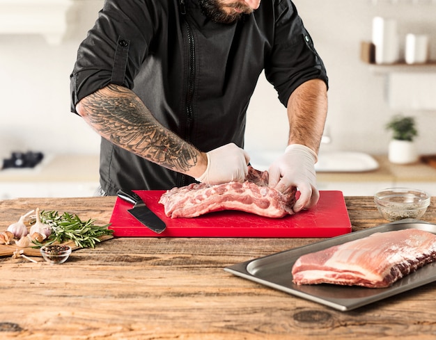 キッチンで肉ステーキを調理する男