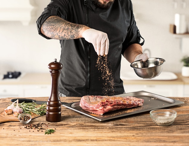 Man cooking meat steak on kitchen