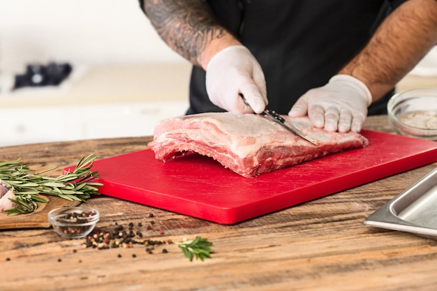 Free photo man cooking meat steak on kitchen