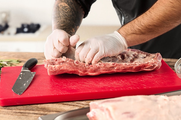 キッチンで肉ステーキを調理する男