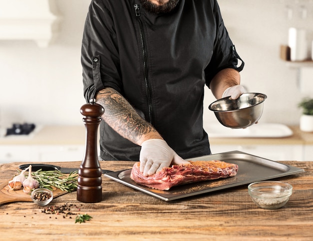 Бесплатное фото Мужчина готовит мясной стейк на кухне