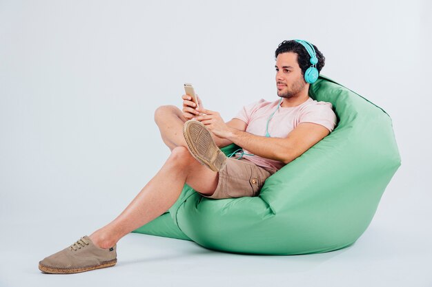 man on couch looking at smartphone
