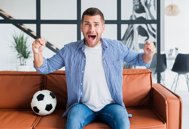 Man on couch watching football game