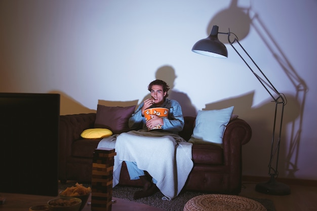 Man on couch watching a movie