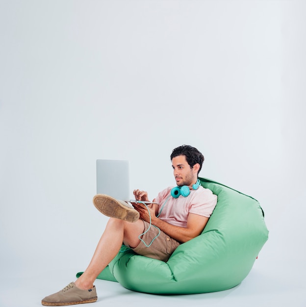 Free photo man on couch with laptop