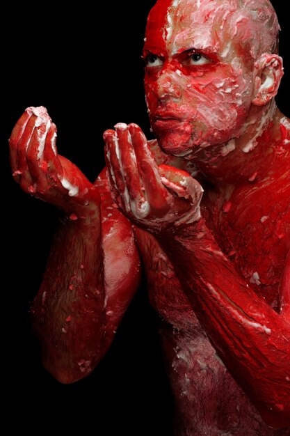 Man covered in red and white paint