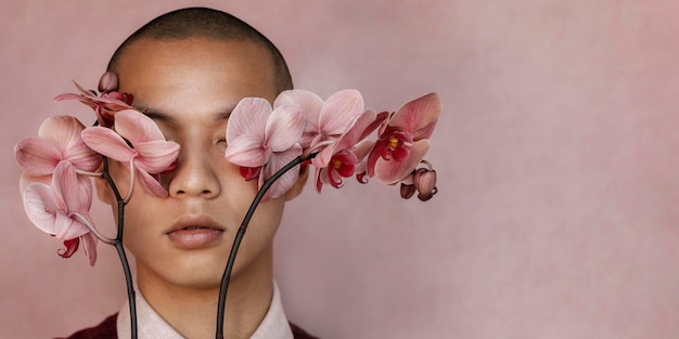 Man covering eyes with flowers