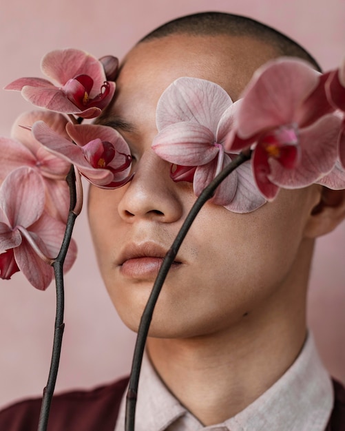 Free photo man covering eyes with flowers