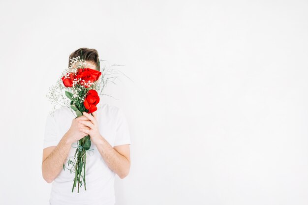 Man covering face with bouquet