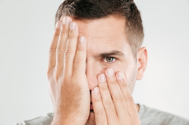 Man covering face with hands.