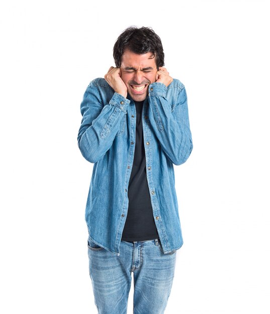 Man covering his ears over white background