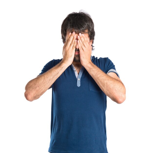 Man covering his eyes over isolated white background