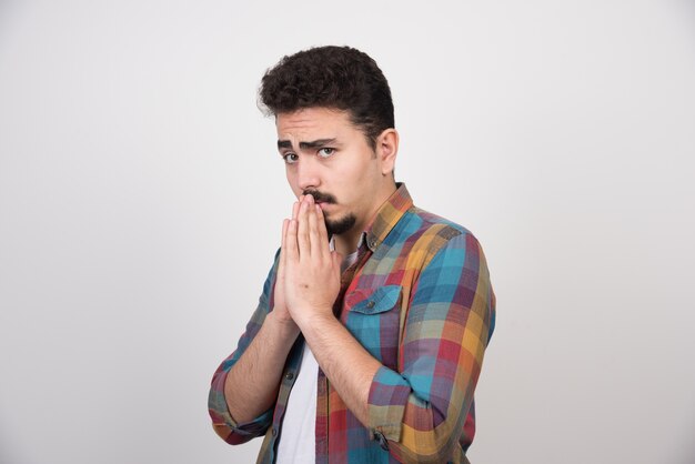 Man covering his mouth with praying hand.