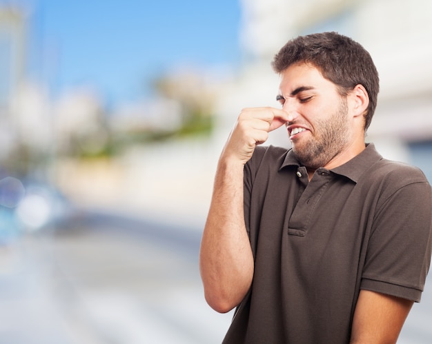 嫌悪感で彼の鼻を覆っている男