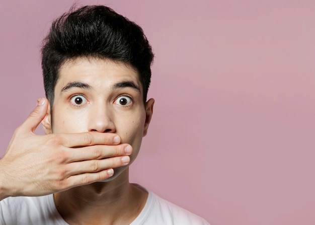 Free photo man covering mouth with hand