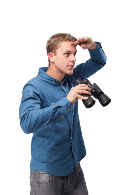 Man covering the sun with his hand and holding binoculars