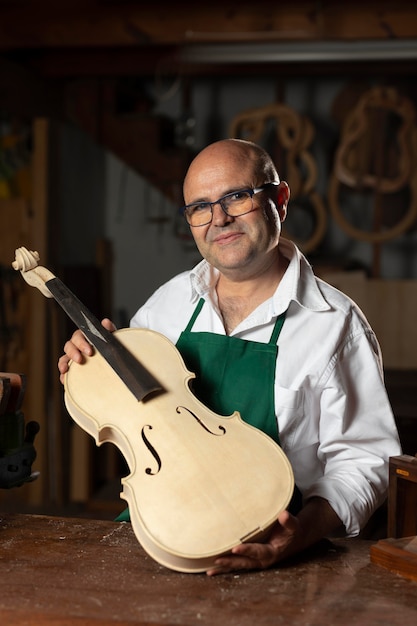 Free photo man crafting an instrument in his workshop