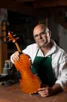 Free photo man crafting an instrument in his workshop