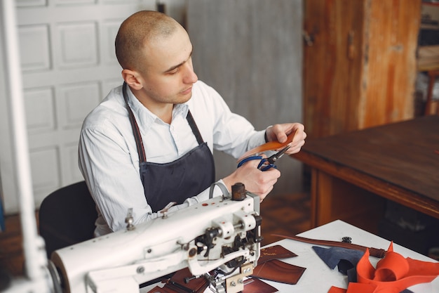 Free photo man  creates leather ware