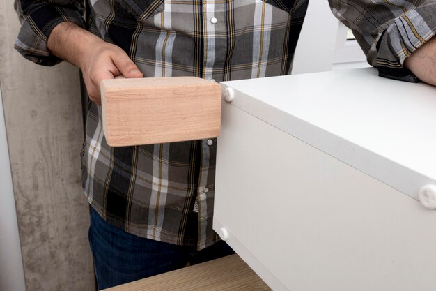 Man creating a cabinet from wood medium