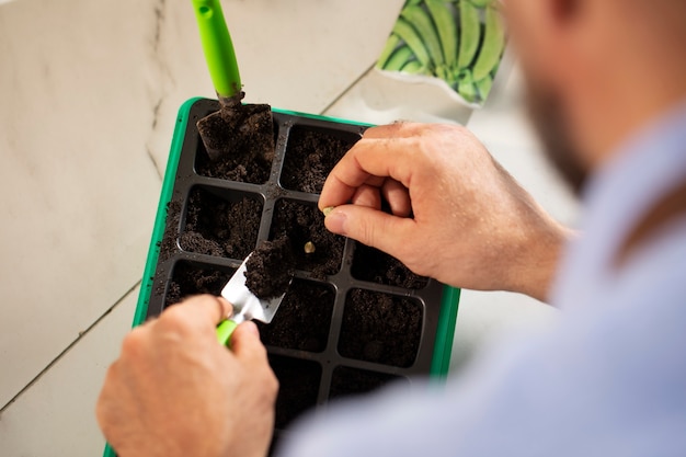 Man cultivating and farming plants in an indoor garden