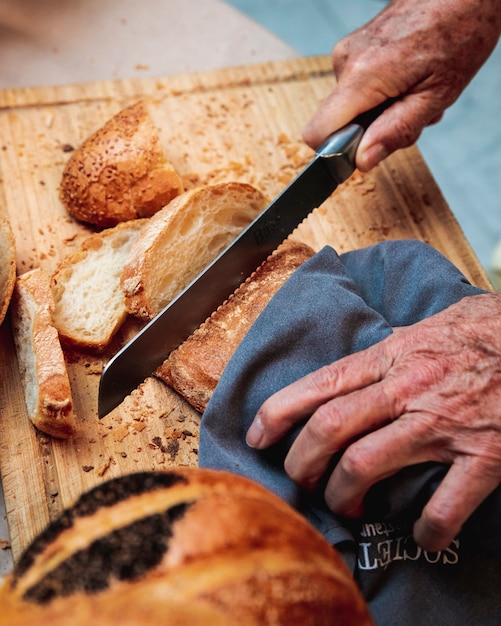 Foto gratuita l'uomo taglia la pagnotta di pane