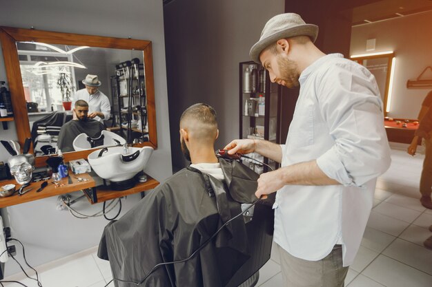 A man cuts hair in a barbershop.