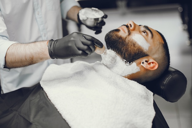 Free photo the man cuts his beard in the barbershop