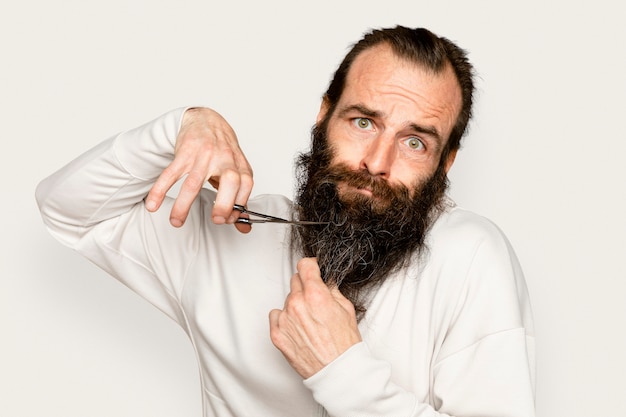 Free photo man cutting beard grooming on white background