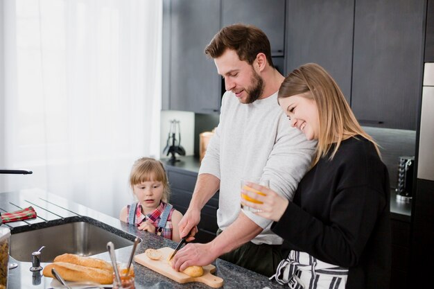 Man cutting bread for family