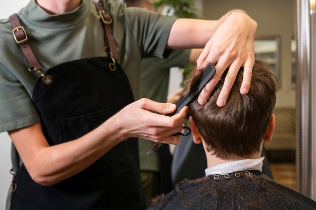 Мужчина стрижет клиенту волосы