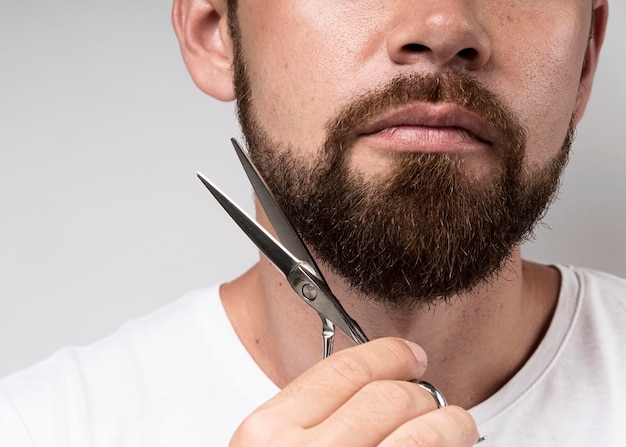 Man cutting his beard close-up