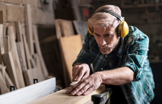 Мужчина режет деревянные доски