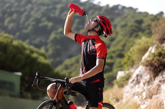 Uomo in bicicletta all'aperto con la sua bici e casco