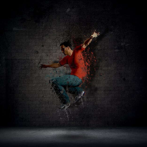 Man dancing against a dark brick wall