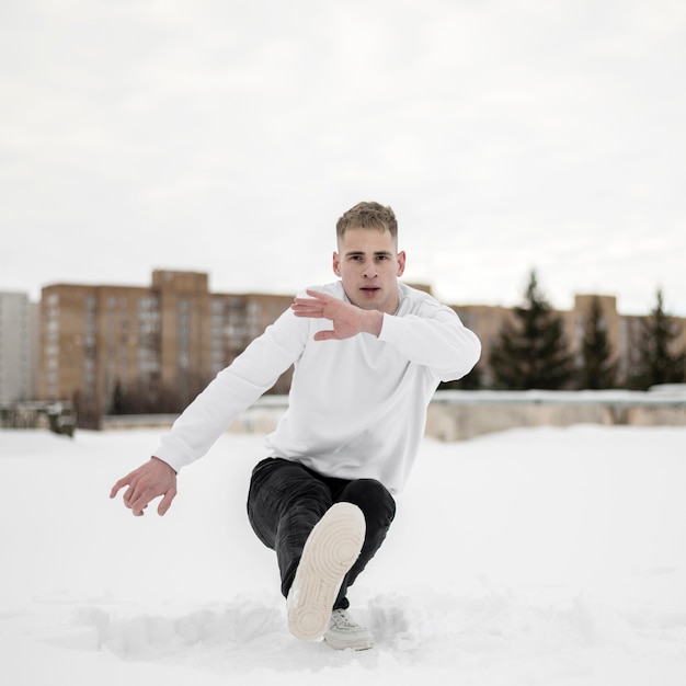 Foto gratuita uomo che balla all'hip hop nella neve