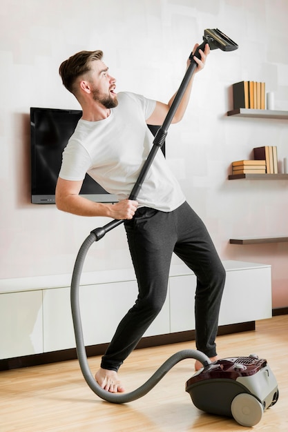 Free photo man dancing with vacuum cleaner