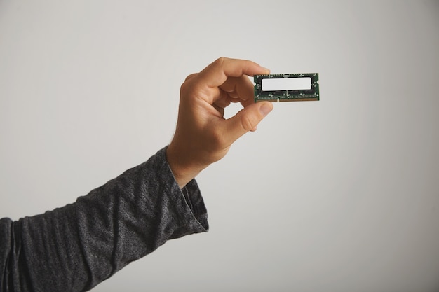 Man in dark gray long sleeve t-shirt holding a memory chip with no label isolated on white, close up
