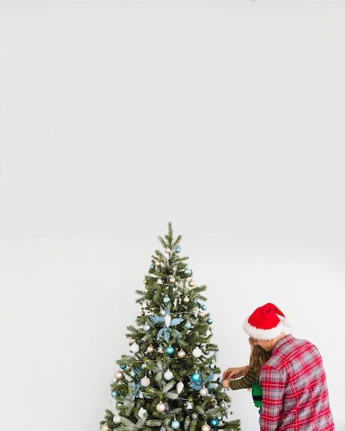 Man and daughter touching christmas tree