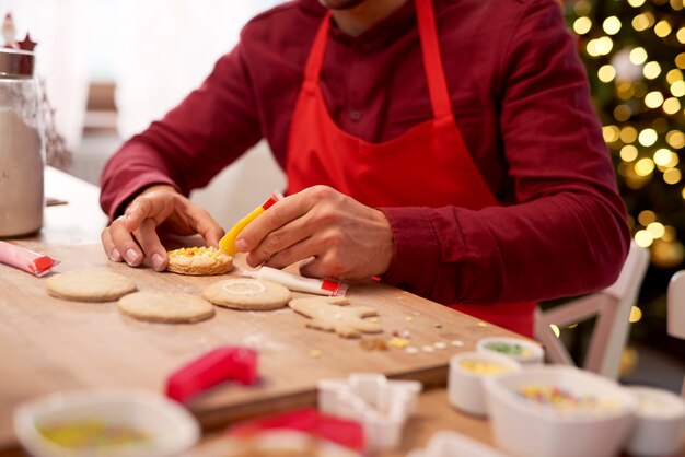 Мужчина украшает печенье на кухне