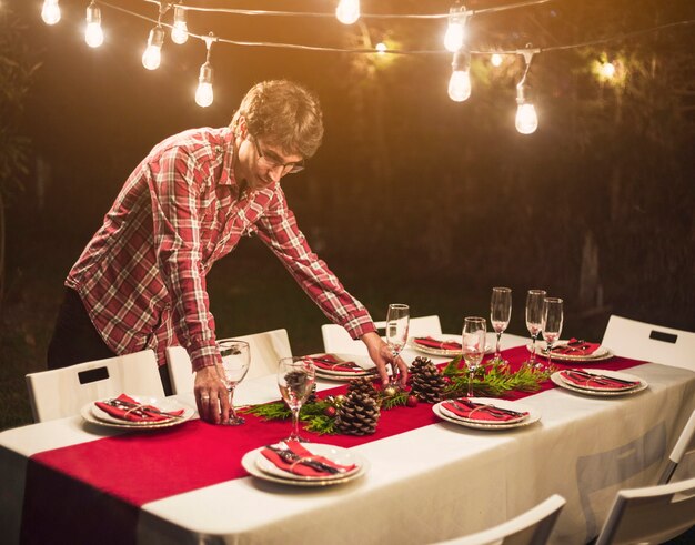 Uomo che decora la tavola con le bagattelle per la festa