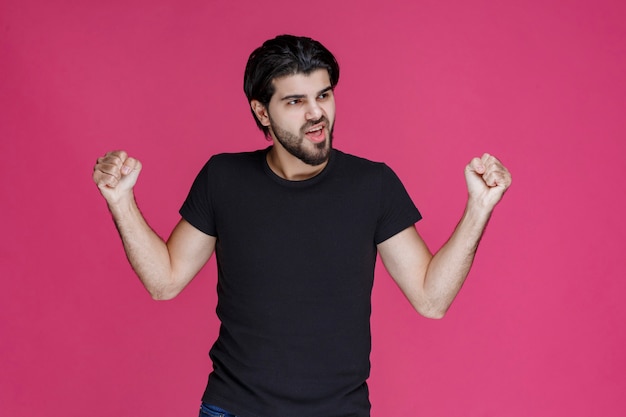 Man demonstrating his fists and muscles and showing that he is powerful and lucky