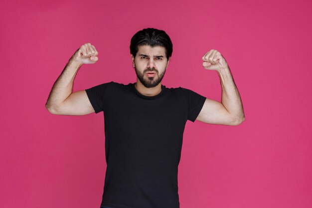 Man demonstrating his fists and muscles and showing that he is powerful and lucky