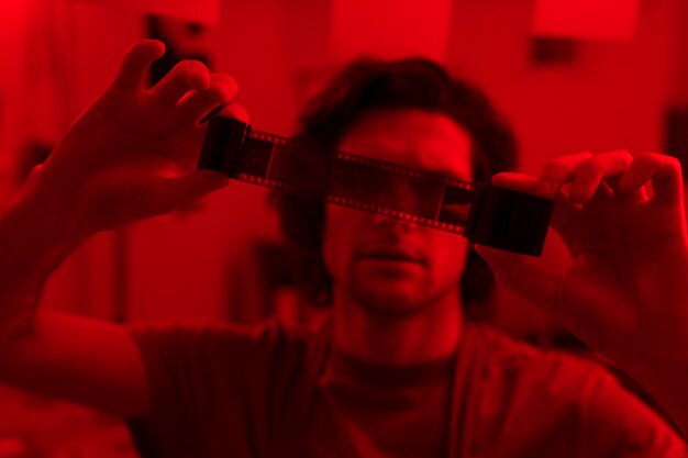 Man developing photos in darkroom front view