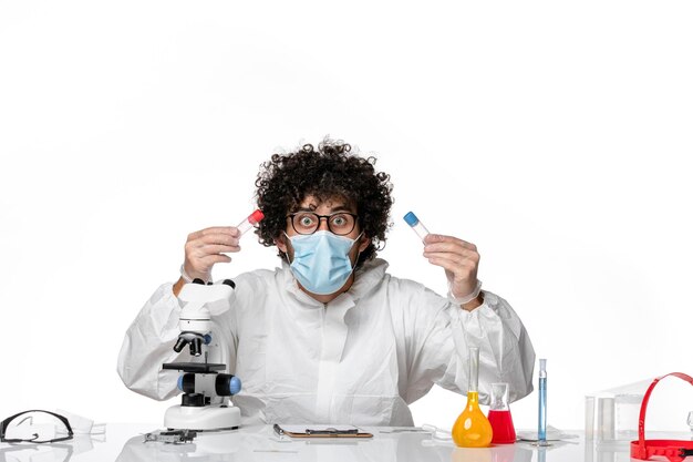 man doctor in protective suit and mask holding flasks on white