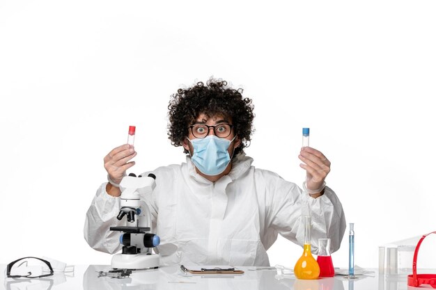 man doctor in protective suit and mask holding flasks on white