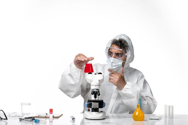 man doctor in protective suit and mask holding flasks with solution on white