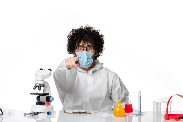 man doctor in protective suit and mask pointing on white